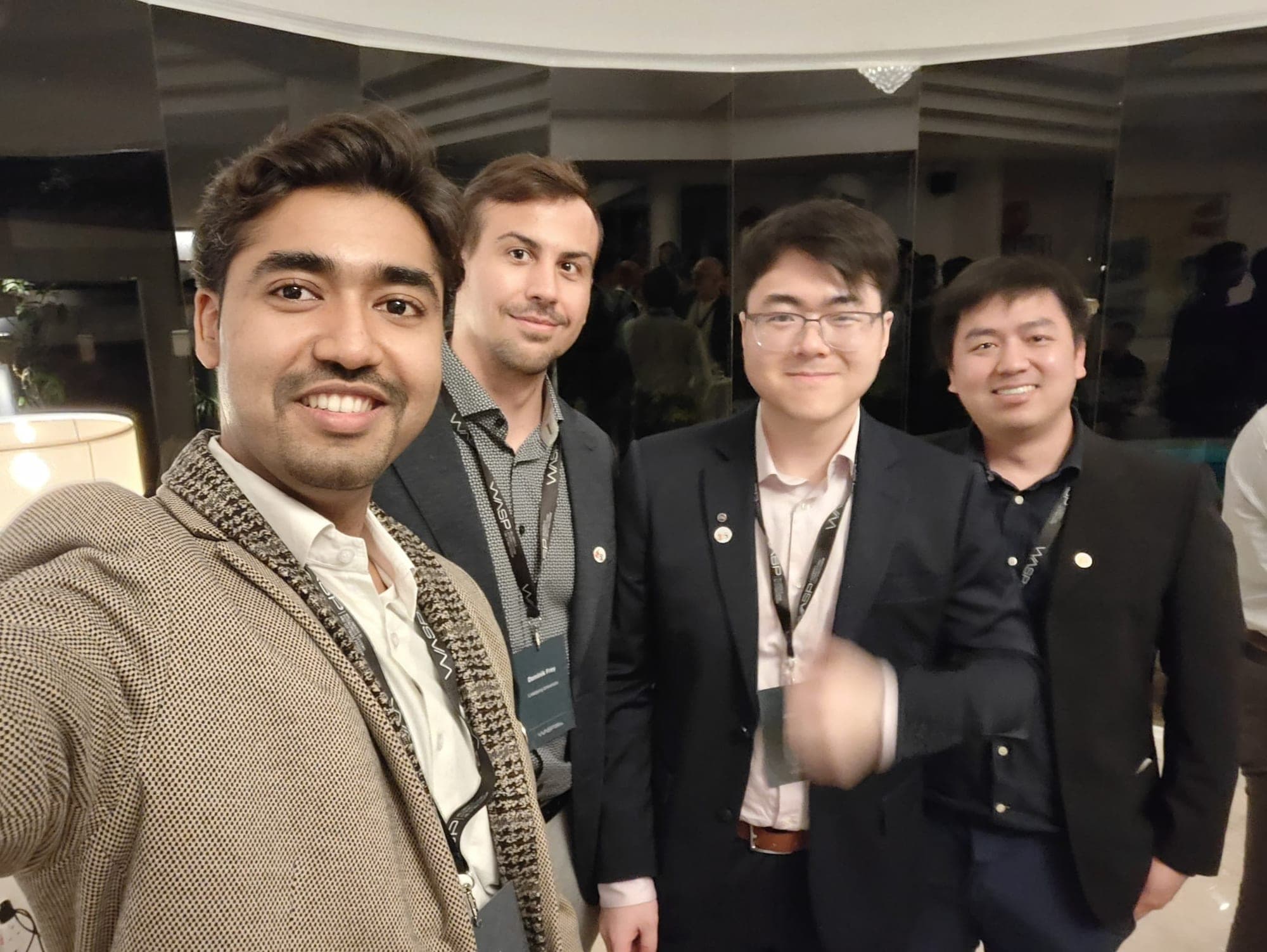 Dominik and three other WASP PhD students in blazers taking a selfie at the reception