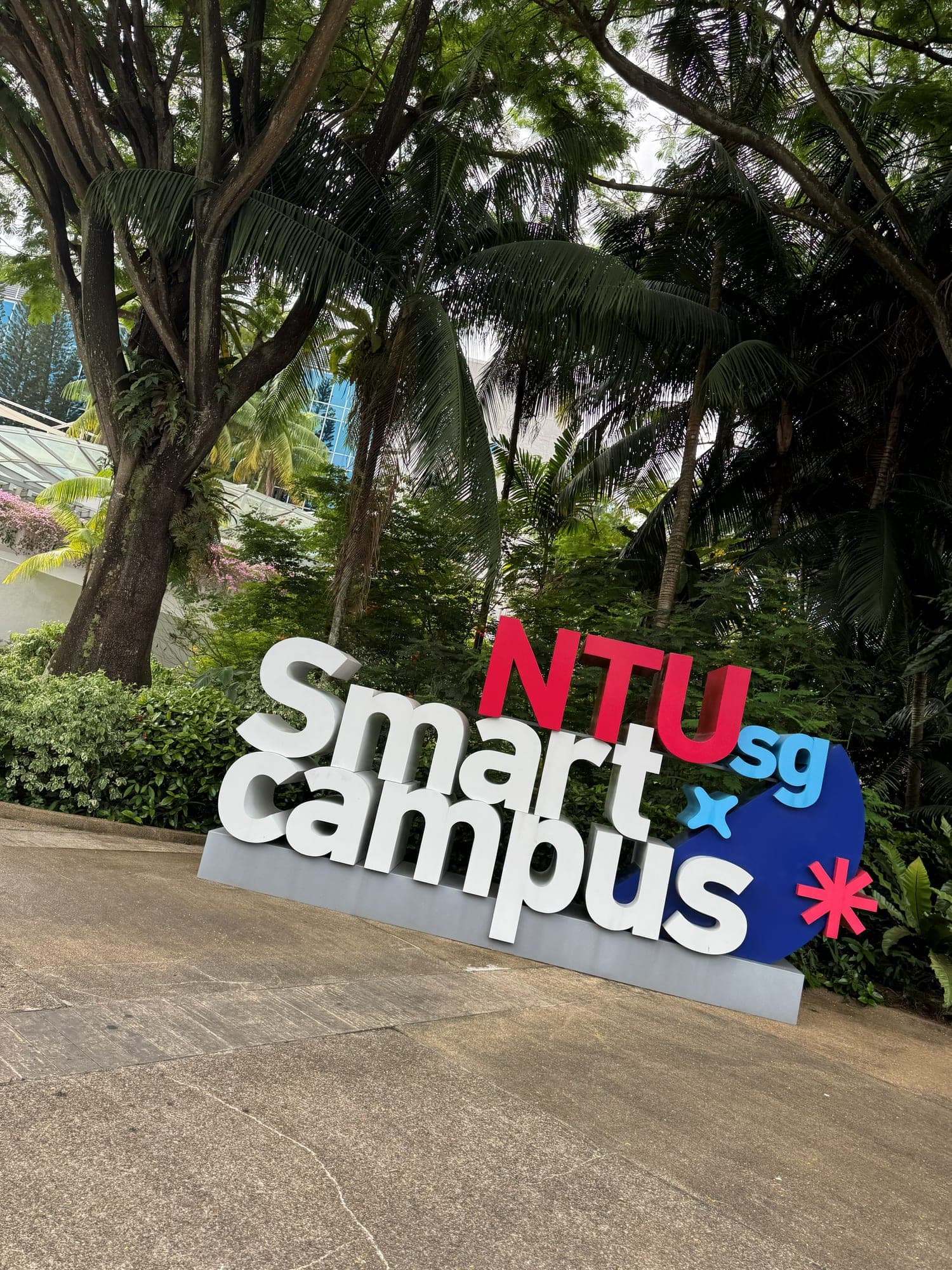 A large NTU Smart Campus sign among tropical trees