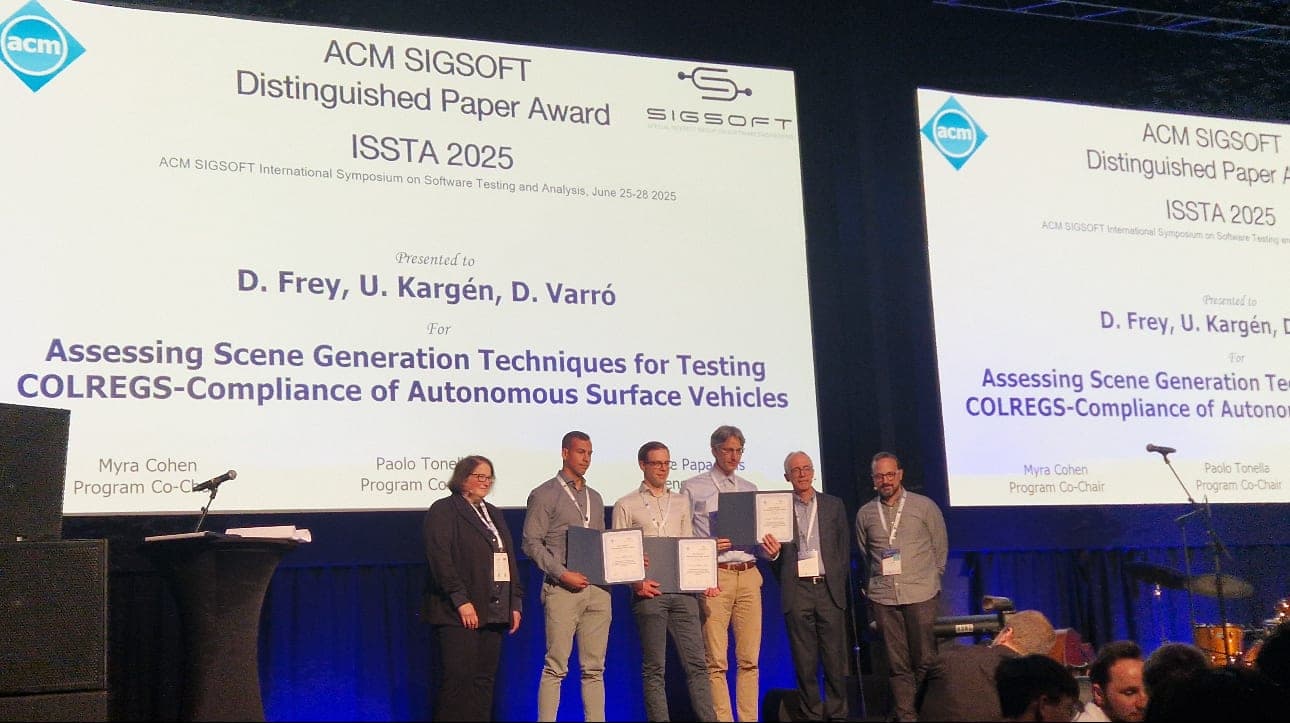 The award ceremony on stage at ISSTA 2025, with the slide naming D. Frey, U. Kargén and D. Varró for the ACM SIGSOFT Distinguished Paper Award