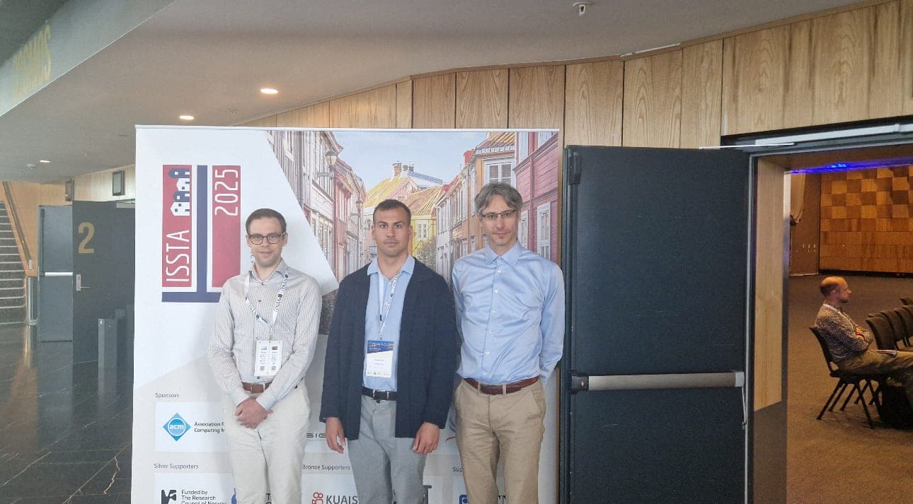 Dominik, Ulf Kargén and Dániel Varró in front of the ISSTA 2025 banner